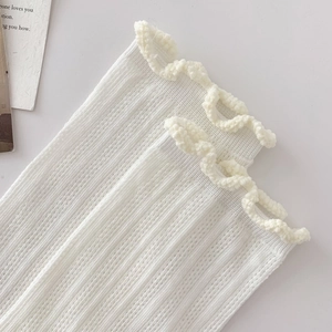 Close-up of white breathable mesh cotton socks featuring elegant ruffle trim and rib texture