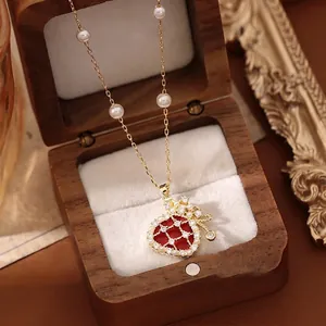 Vintage gold plated pearl necklace with red lucky bag pendant and zircon accents