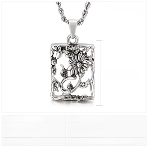 Detail of vintage stainless steel rectangular pendant with sunflower and vine patterns
