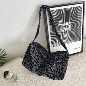 Detailed close-up of a grey leopard print tote bag with a soft velvet-like fabric texture