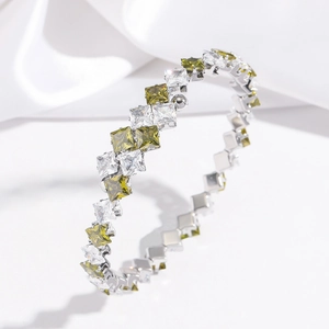 Detail of silver stainless steel bangle with green and white square-cut zircon stones