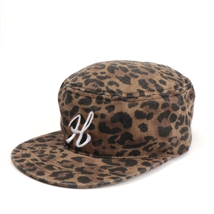 Dettaglio di un cappello militare leopardato con ricamo della lettera H bianca