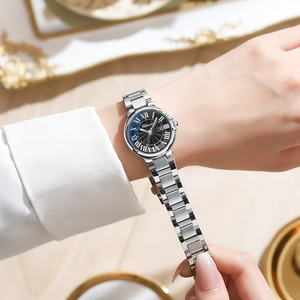 Close-up of women's quartz watch with black roman dial and stainless steel strap on wrist