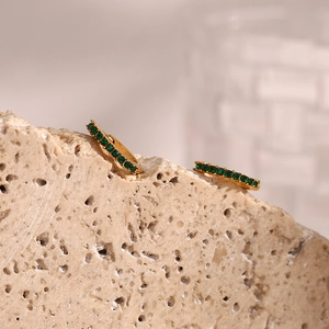 Detail showing 18K gold-plated mini hoops with micro-set green zircons on a rock