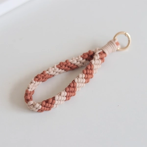 Macro detail of hand-woven cotton wristlet keychain with beige and brown striped texture
