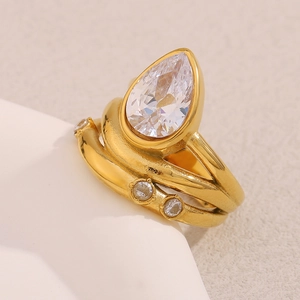 Detail of 18K gold-plated multi-layer ring with teardrop cubic zirconia on white prop
