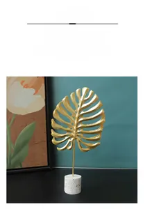 Golden monstera leaf ornament on marble base for luxury living room desktop decor