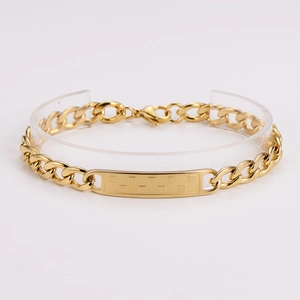 Macro detail of gold-plated cuban link bracelet with textured rectangle plate and lobster clasp