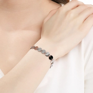 Close-up of polished silver disc link bracelet worn on a wrist for a minimalist style