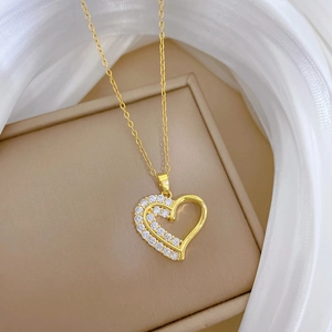 Détail macro d'un collier doré double épaisseur avec un pendentif en forme de cœur