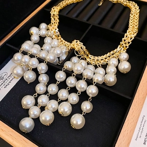 Chic gold-tone letter M chain necklace featuring oversized dangling white pearls