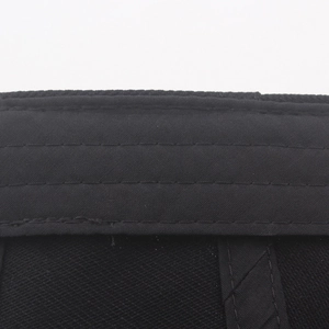 Detailed close-up of the black cotton fabric beret showing reinforced parallel stitching lines