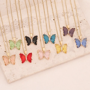 Macro shot of colorful butterfly pendants with gold plating and cubic zirconia on stone base
