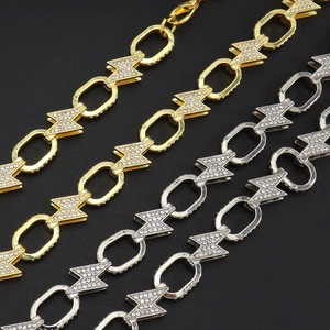 Close-up of gold and silver cuban necklaces with rhinestone-encrusted lightning bolts