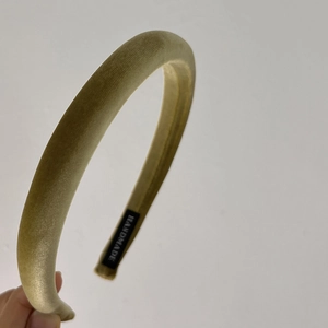 Detail showing the inner handmade label and velvet texture of the beige padded headband