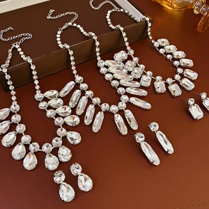 Vue détaillée de colliers à pompons gouttes argentés et ensembles de boucles d'oreilles