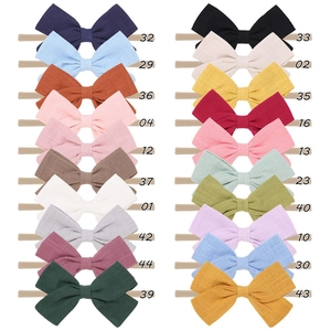 Detailed grid display of 20 color options for nylon bow headbands in soft fabric