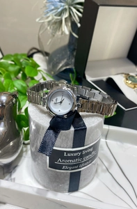 Silver stainless steel watch with white round dial displayed on marble texture