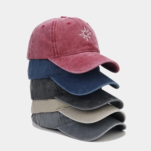 Detailed close-up of sun embroidery on various colors of washed cotton baseball caps