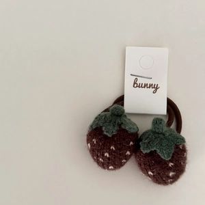 Pair of knitted strawberry hair ties with brown base and green leaves on white card