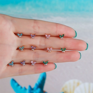 Detailed macro view of four butterfly stud earrings with colorful zircon inlay