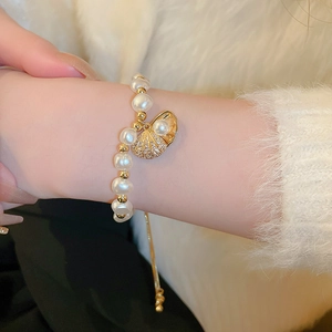 Detail of adjustable shell bracelet with irregular pearls and sparkling zircon accents