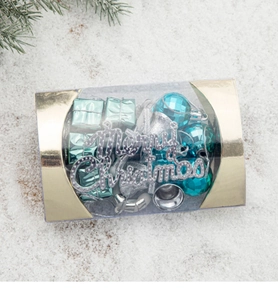 Close-up of blue ornaments, silver bells and green gift boxes in a luxury gift box