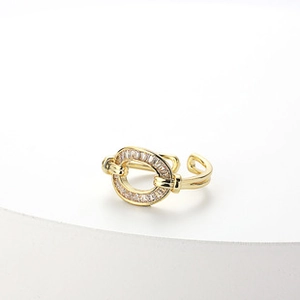 Detail of gold-plated adjustable ring with interlocking bands and pavé-set zircon crystals