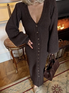 Détail de robe longue en maille côtelée marron foncé avec col en V et boutons sur le devant