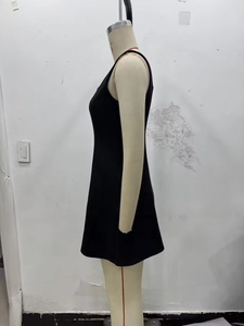 Dettaglio dell'abito nero senza maniche con silhouette a trapezio e taglio aderente chic