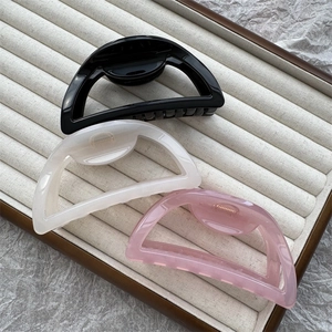 Three jelly color shark hair clips in black, beige and pink on a jewelry tray