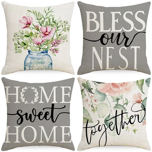 Detail view of four floral and typographic linen cushion covers with rustic patterns