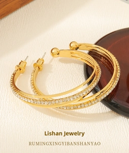 Close-up of gold-plated hoop earrings with sparkling cubic zirconia inlay and pin closure