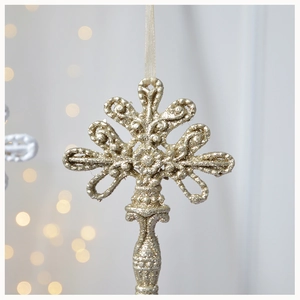 Detailed close-up of a gold glitter Christmas ornament with ornate European patterns