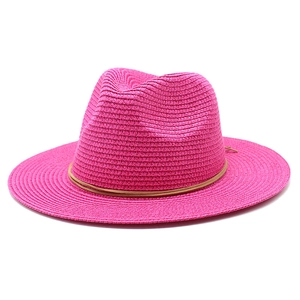 Close-up of rose red straw fedora hat featuring a fine brown leather band and texture