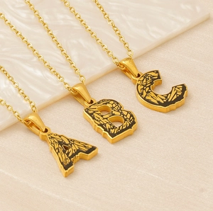 Detail of letters A, B, C gold necklaces with black texture and classic O-chain