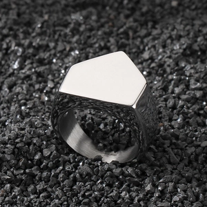 Macro view of silver geometric 316L stainless steel ring on black stones