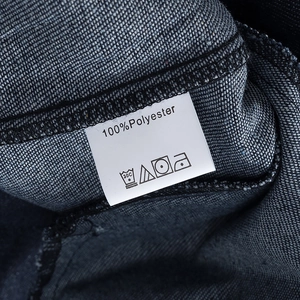 Detail of 100% polyester care label and washing symbols on denim jacket fabric