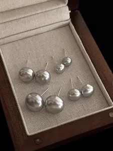 Set di orecchini a perno con perle grigio argento di varie dimensioni in una scatola di legno