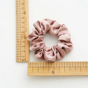 Premium satin scrunchie in dusty rose with a 10cm diameter shown on a scale ruler