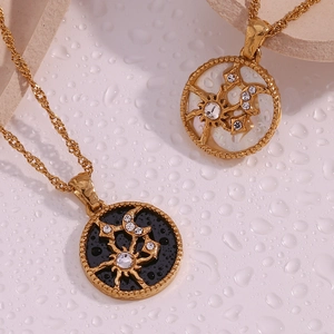 Close-up of sun and moon 18K gold plated pendants with crystals on a water droplet base
