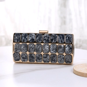 Detail of grey marble texture acrylic clutch bag with elegant gold metal frame and clasp