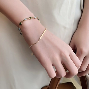 Bracelet chaîne double couche plaqué or vintage avec pierres ovales vertes et grises sur poignet