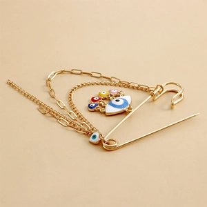 Detail of gold brooch with blue evil eye pendant and colorful tassel chains