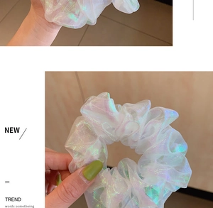 Detail of iridescent white organza scrunchie with blue-green holographic shimmer