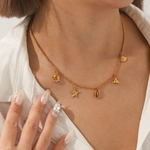 Gold stainless steel ocean necklace with turtle starfish and seashell charms on model