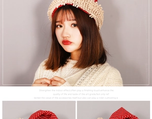 Detail of beige knit Christmas hat featuring festive red polka dot patterns on kids