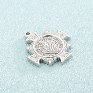 Macro detail of silver exorcist pendant with intricate engraving on light blue background