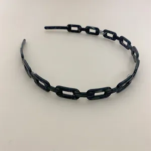 Detail of acetate chain headband featuring dark blue marble texture and cutout links