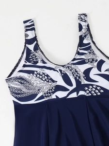 Detail of printed tankini top with blue floral pattern and navy pleated hemline